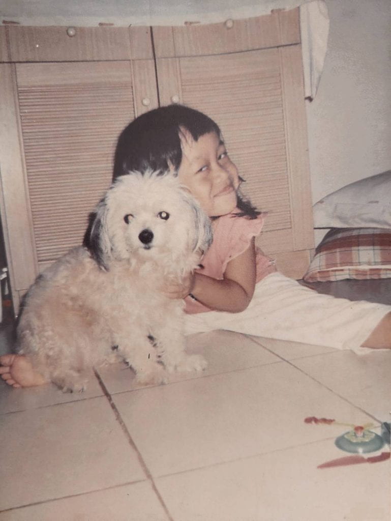 Young Tesa with her white dog Priti. 